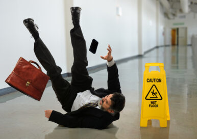 man-in-suit-slips-on-smooth-wet-floor-caution-sign